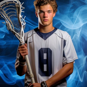 May include: A young man wearing a white lacrosse jersey with a blue number 8 on the front. He is holding a lacrosse stick in his right hand. The background is a blue and white smoke effect.