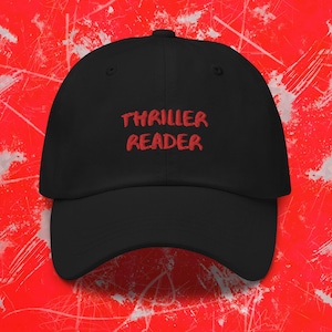 Puede incluir: Gorra de béisbol negra con texto bordado en rojo que dice "THRILLER READER".