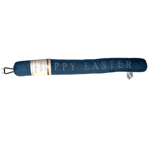 May include: A blue denim doorstop with the text "Happy Easter" embroidered in white. The doorstop is wrapped in a white and gold label.