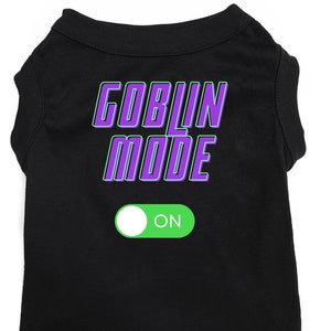 May include: Black dog t-shirt with purple text that says "Goblin Mode" and a green and white toggle switch that says "ON".
