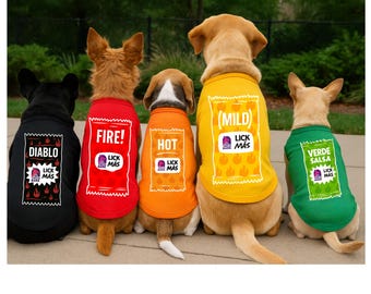 May include: Five dogs wearing themed dog shirts. The shirts are black, red, orange, yellow, and green. Each shirt has a different label design with the words "DIABLO", "FIRE!", "HOT", "(MILD)", and "VERDE SALSA" printed on them. The shirts also have the "LICK MAS" logo.