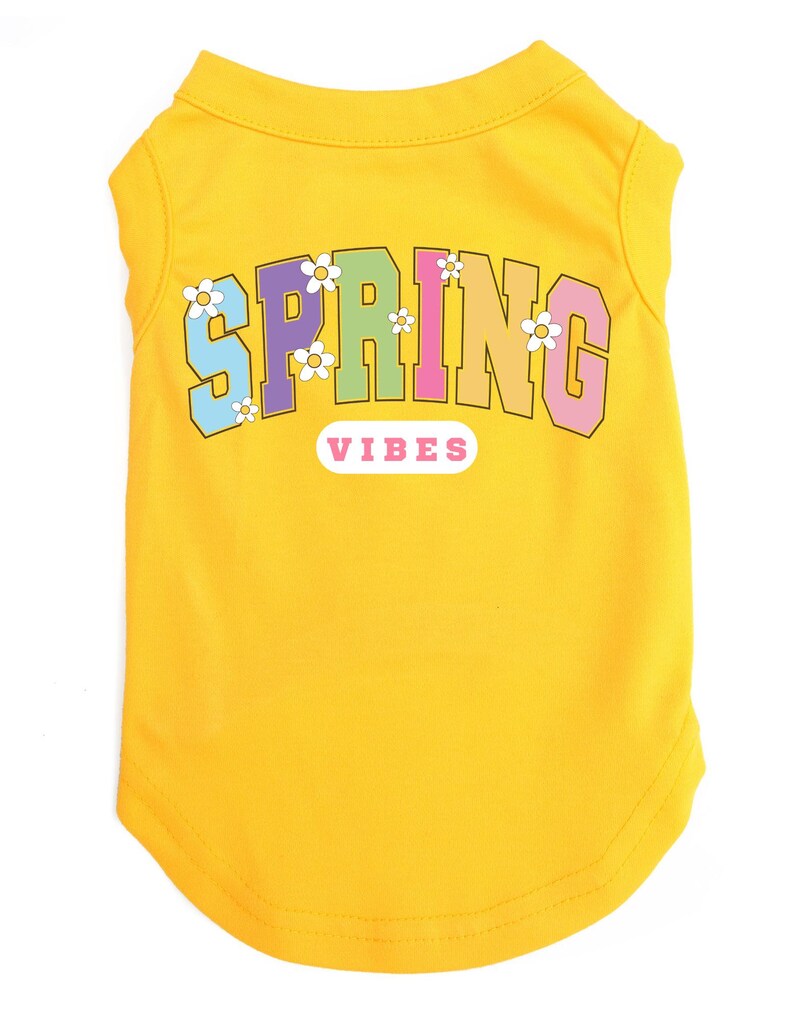 May include: Yellow sleeveless dog shirt with the text "SPRING VIBES" in rainbow colors with white flowers around the text.