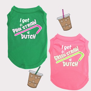 May include: Two dog shirts with a green and pink color scheme. The shirts have a graphic of a straw and the text "I get the PINK/GREEN STRAW at DUTCH".