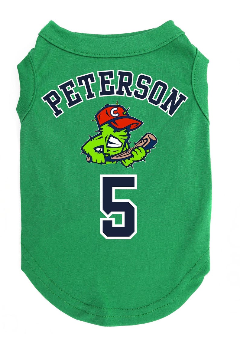May include: Green pet jersey with the name "PETERSON" in white outlined in navy blue. A cartoon cactus wearing a red baseball cap and holding a bat is centered above the number "5".