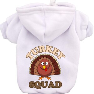 May include: White hooded sweatshirt with a cartoon turkey graphic and the text "TURKEY SQUAD" printed on the back.