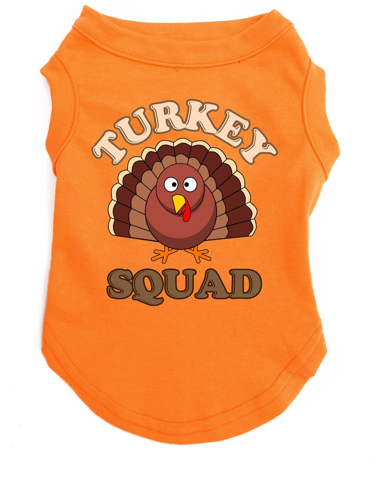 May include: Orange sleeveless dog shirt with a cartoon turkey graphic and the text "TURKEY SQUAD".