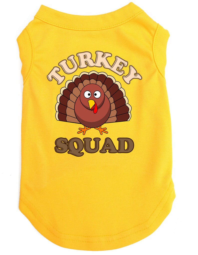 May include: Yellow sleeveless dog shirt with a cartoon turkey graphic and the text "TURKEY SQUAD".