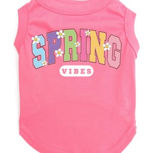 May include: Pink sleeveless dog shirt with a rainbow colored "SPRING VIBES" graphic with white daisies.