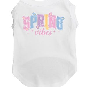May include: White dog shirt with a colorful "SPRING vibes" graphic with flowers.