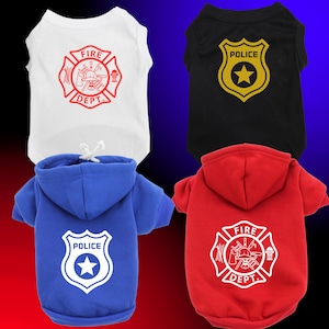Może przedstawiać: Cztery elementy odzieży dla zwierząt: biały top bez rękawów z czerwonym emblematem Fire Dept., czarna koszula ze złotą odznaką policji, niebieska bluza z kapturem z białą odznaką policji i czerwona bluza z kapturem z białym emblematem Fire Dept.