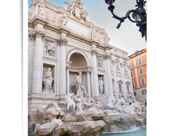 May include: A photograph of the Trevi Fountain in Rome, Italy. The baroque fountain features sculptures of mythical figures, cascading water, and a light blue pool. The sky is a clear blue. The text "no physical print is shipped" is at the top.