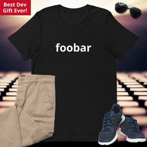 May include: Black t-shirt with the word "foobar" printed in white on the front. The shirt is shown on a model wearing khaki pants and sneakers.