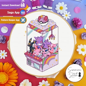 May include: Cross stitch pattern featuring a pixelated illustration of a claw machine filled with Pokemon characters. The machine is pink and purple with a rainbow inside. The Pokemon characters include Gengar, a purple ghost Pokemon, and a few pink and purple fairy Pokemon.