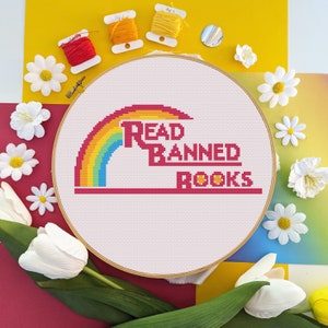 May include: A white embroidery hoop with a rainbow and the text "Read Banned Books" in red and yellow letters.