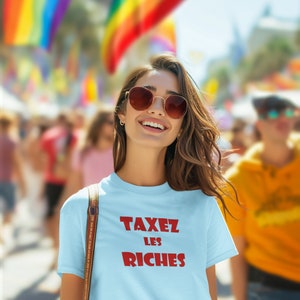 May include: A light blue t-shirt with the text "TAXEZ LES RICHES" in red.