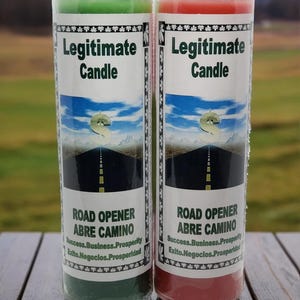 May include: Two cylindrical glass jar candles, one with green wax and one with red wax. Each label features the text Legitimate Candle, Road Opener, Abre Camino, Success, Business, Prosperity, Exito, Negocios, Prosperidad and a dollar sign graphic.