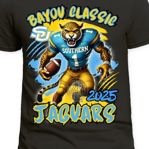 May include: Black t-shirt featuring a jaguar football player illustration. The jaguar is wearing a blue and gold uniform and holding a football. Text on the shirt includes "Bayou Classic", "Southern", "Jaguars", and "2025".