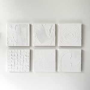 May include: Six white square canvases with different raised textured patterns. The canvases are arranged in two rows of three.