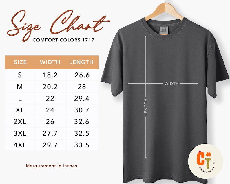 以下が含まれることがあります： 木製のハンガーに掛けられた濃い灰色のComfort Colors 1717 Tシャツ。画像には、Sから4XLまでのサイズのインチ単位の測定値を含むサイズチャートが含まれています。チャートはシャツの幅と長さを表示しています。
