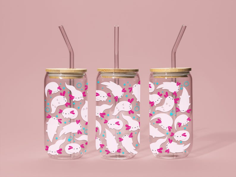 May include: Three clear glass tumblers with bamboo lids and pink and white axolotl illustrations. Each tumbler has a clear plastic straw.