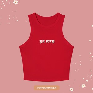 K&ouml;nnte beinhalten: Ein rotes Crop-Top mit dem wei&szlig;en Text "ya wey" mittig auf der Vorderseite. Das Top ist &auml;rmellos mit rundem Ausschnitt. Der Hintergrund ist hellrosa mit wei&szlig;en Blumen- und Punktakzenten.