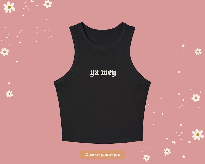 K&ouml;nnte beinhalten: Schwarzes geripptes Tanktop mit dem Text "ya wey" in wei&szlig;er gotischer Schrift. Das Top ist &auml;rmellos mit einem runden Ausschnitt. Der Hintergrund ist einfarbig rosa mit wei&szlig;en Blumen- und Punktakzenten.