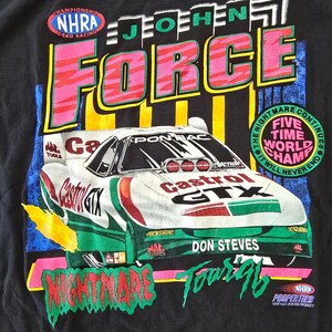 May include: Black t-shirt featuring a race car with "Castrol GTX" and "Don Steves" text. The design includes "NHRA Drag Racing" and "Nightmare Tour '96" graphics in vibrant colors. The shirt also has "Five Time World Champ" text.
