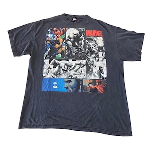 May include: Dark gray Marvel Comics t-shirt featuring comic book panels of various superheroes, including Captain America, Hulk, and Spider-Man. The word "MARVEL" is printed in red across the top. The shirt is made of a soft, worn material.