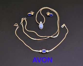 Parure vintage Avon. Ensemble collier, bracelet et boucles d'oreilles. Plaqué or avec inserts en verre bleu et strass transparents. Entièrement signé  