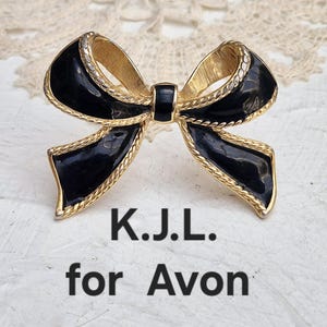 Broche de lazo vintage de Kenneth Jay Lane para Avon, dorado con esmalte negro. Firmado por K.J.L. para Avon.