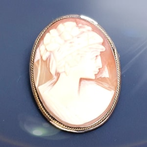 Antica spilla con cammeo edoardiano su conchiglia su montatura in argento 800. Signora con il cappello. Timbrato 800, anni '10
