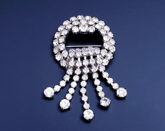 Prachtige vintage art-deco ronde watervalbroche gerhodineerd met heldere strassteentjes.