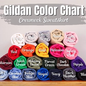 May include: A Gildan crewneck sweatshirt colour chart, displaying rolled fabric samples in various shades. Colours include white, ash, sport grey, sand, light pink, red, orange, gold, and others. The text "Gildan Color Chart Crewneck Sweatshirt" is at the top.
