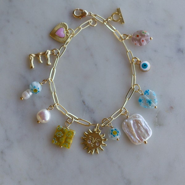 Swim the Sea Charm Bracelet: pink heart charm, baroque pearl, millefiori beads, letter initial charm, sun charm, evil eye, zodiac charm