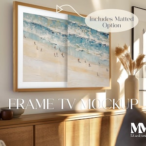 Puede incluir: Una maqueta de TV enmarcada con una obra de arte que representa una escena de playa. La TV está montada en una pared sobre un gabinete de madera. El texto "FRAME TV MOCKUP" es visible debajo de la TV. El texto "Includes Matted Option" es visible en la esquina superior derecha de la imagen.