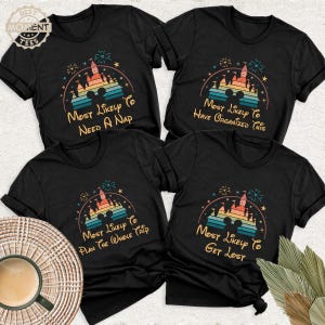 May include: Four black t-shirts with colorful graphic designs. Each shirt features a castle silhouette, Mickey Mouse ears, and text: "Most Likely To Need A Nap," "Most Likely To Have Organized This," "Most Likely To Plan The Whole Trip," and "Most Likely To Get Lost."