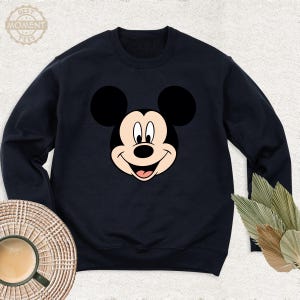 May include: A black sweatshirt featuring a cartoon image of Mickey Mouse's face.