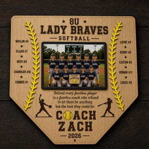 May include: A wooden softball team plaque in the shape of home plate. It features a team photo, player names, and the text "8U Lady Braves Softball." The plaque includes the coach's name and the year 2026.