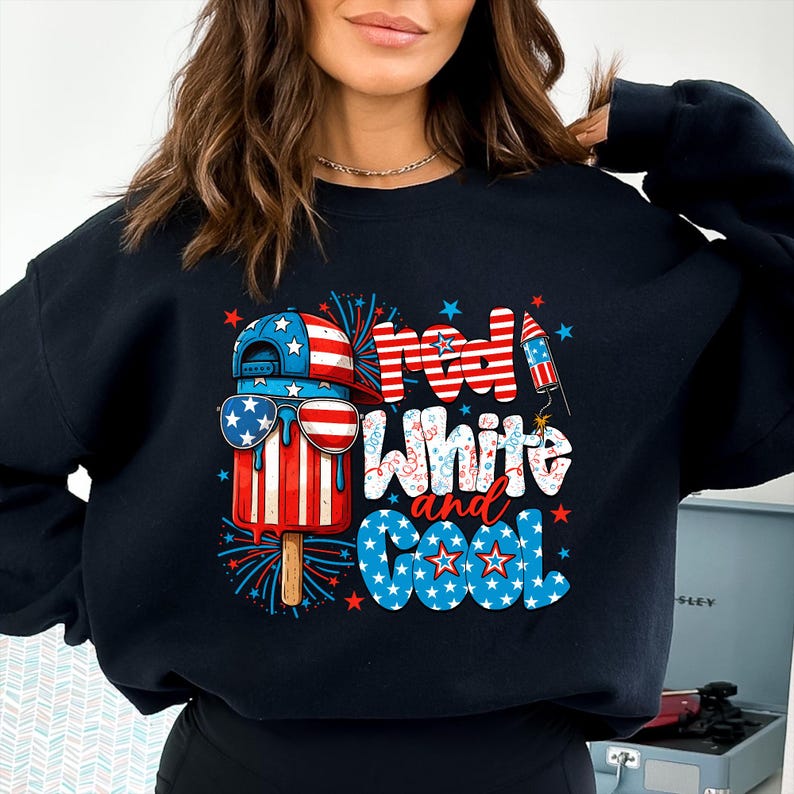 May include: Black sweatshirt with a patriotic design. The graphic features a popsicle wearing sunglasses and a baseball cap, with the text "Red, White, and Cool" in red, white, and blue.