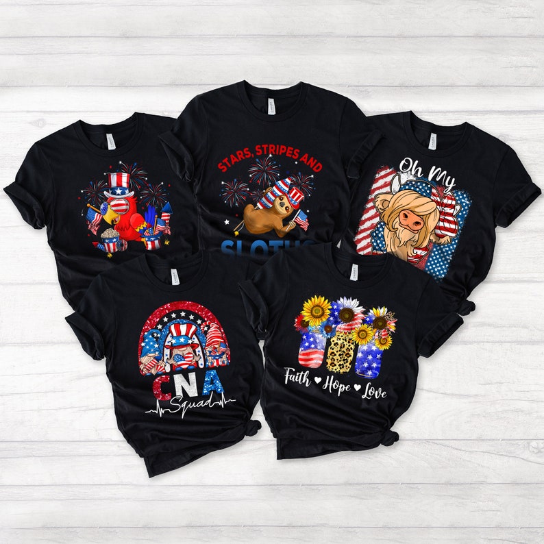 May include: Five black t-shirts with different patriotic designs. The designs include a sloth wearing a red, white, and blue hat, a highland cow wearing a red, white, and blue bandana, a rainbow with a heart and the text "CNA Squad", a sunflower with the text "Faith Hope Love", and a red, white, and blue parrot holding a popcorn bucket.