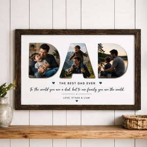 May include: A framed print with the word "DAD" in large letters, each letter containing a photograph of a father and child. The text reads "THE BEST DAD EVER" and "To the world you are a dad, but to our family you are the world."