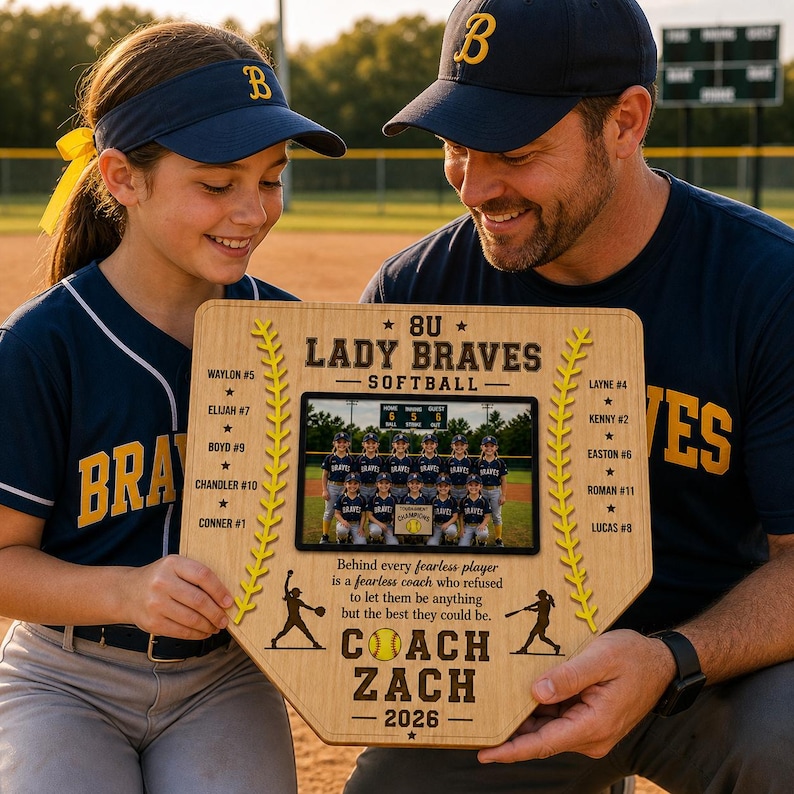 May include: A wooden baseball home plate-shaped plaque featuring a team photo and text. The plaque reads "8U Lady Braves Softball" and includes player names and coach information. The team is wearing navy blue and white uniforms.