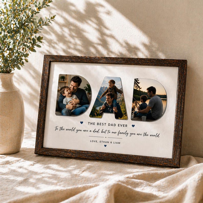 May include: A framed photo collage with the word "DAD" in large letters, each letter containing a different family photo. The frame is dark brown, and the text "THE BEST DAD EVER" and a loving message are below the photos.