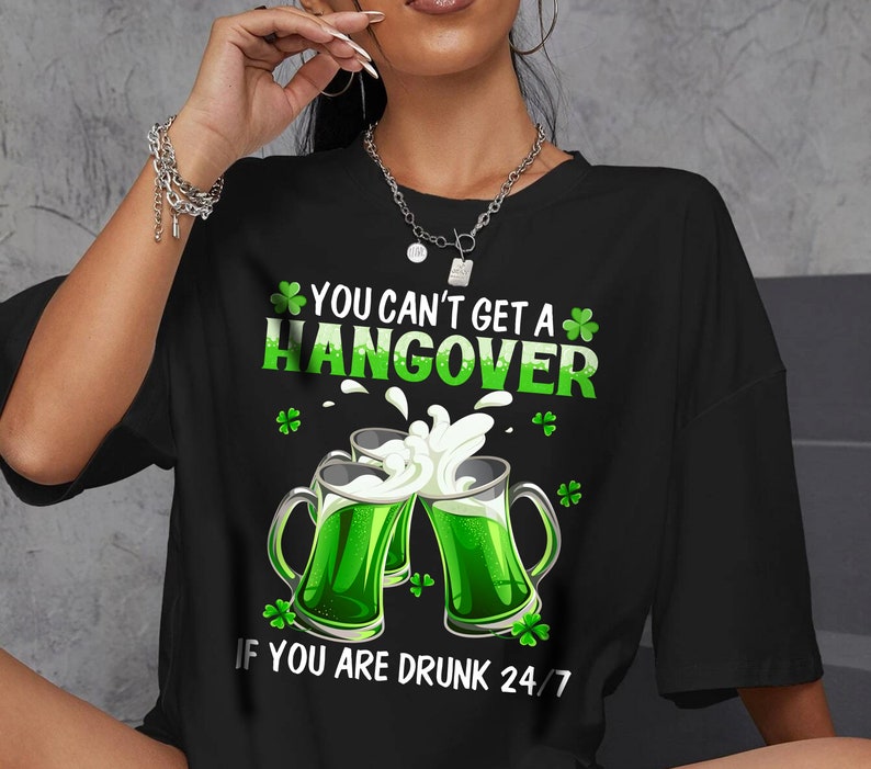 May include: Black t-shirt with a green shamrock design and the text "You can't get a hangover if you are drunk 24/7".