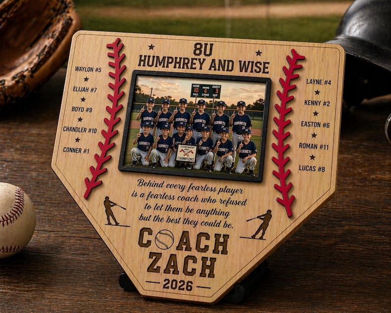 May include: A wooden baseball-themed plaque with a photo of a team, red stitching, and player names. The plaque reads "8U Humphrey and Wise" and "Coach Zach - 2026." A baseball and glove are visible.