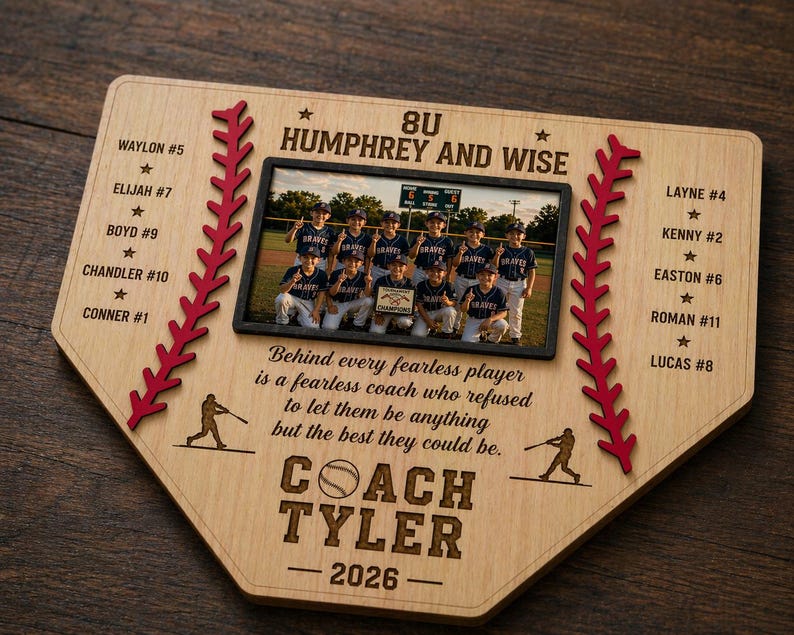 May include: A wooden baseball-shaped plaque with a team photo, player names, and the text "8U Humphrey and Wise." The plaque includes red stitching, baseball player silhouettes, and the coach's name, "Coach Tyler," with the year 2026.