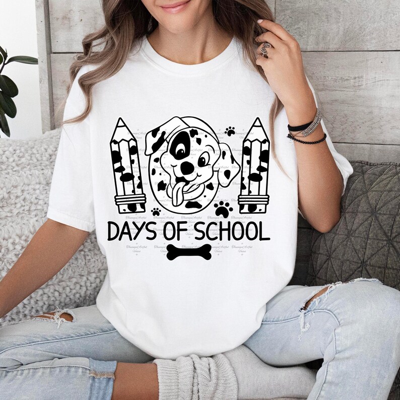 May include: White t-shirt with a black and white illustration of a Dalmatian dog wearing a graduation cap. The text "101 Days of School" is printed below the dog. A black and white bone is printed below the text.