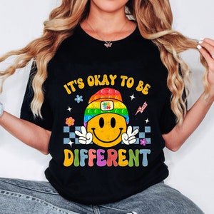 May include: Black t-shirt with a rainbow smiley face and the text "It's okay to be different".