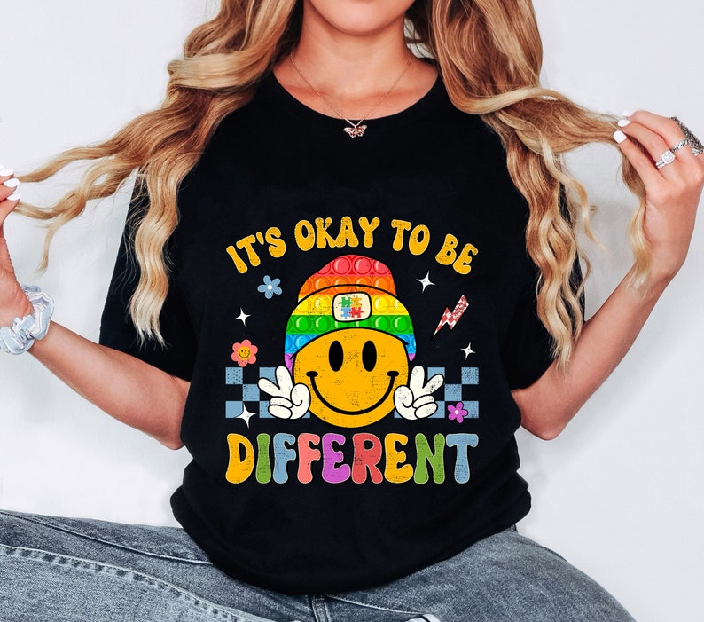 May include: Black t-shirt with a rainbow smiley face and the text "It's okay to be different".