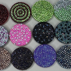 Peut inclure: Douze poignées de téléphone rondes avec différents motifs en strass. Les motifs comprennent un tourbillon, une couleur unie, un imprimé léopard et un motif moucheté. Les poignées mesurent toutes environ 3,8 cm de diamètre.